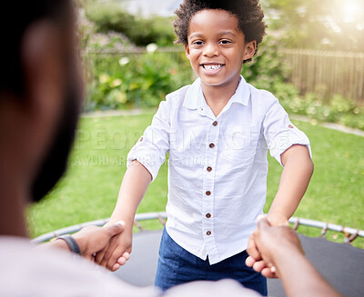 Buy stock photo Shot of a little boy jumping on a trampoline with his father outdoors