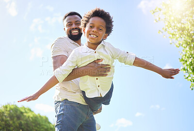 Buy stock photo Low angle shot of a father carrying his son while playing together outdoors