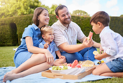 Buy stock photo Mother, father and kids picnic in park for weekend bonding, eating and happy family on grass together. Mom, dad and children in garden with healthy food, fruit and smile in backyard for outdoor lunch