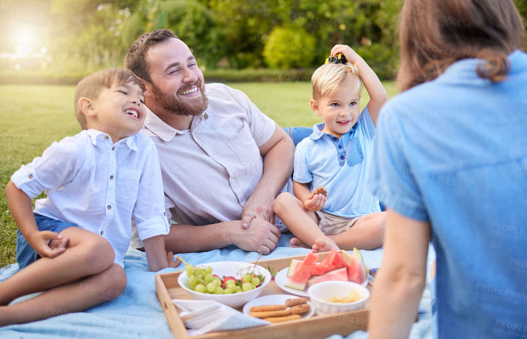 Buy stock photo Shot of a young family having a picnic at the park