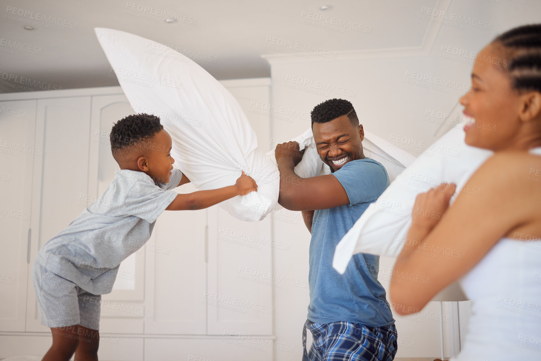 Buy stock photo Dad, mom and child in pillow fight in bedroom with morning games, bonding or playful happy family in home. Mother, father and son playing together on bed with love, fun and smile with energy in house