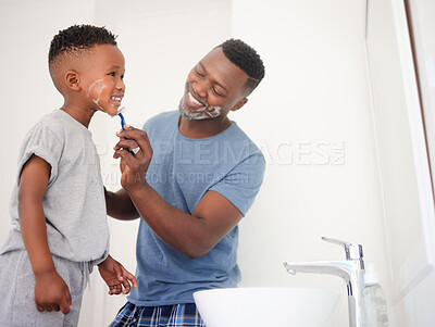 Buy stock photo Shot of a father teaching his son how to shave in the bathroom at home