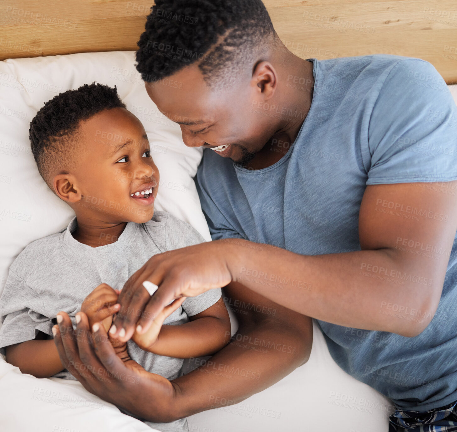 Buy stock photo Black family, happy and father with son in bedroom for bonding, connection and love for child care in house. Male parent, boy kid and relax in bed for embrace on fathers day, together and weekend fun