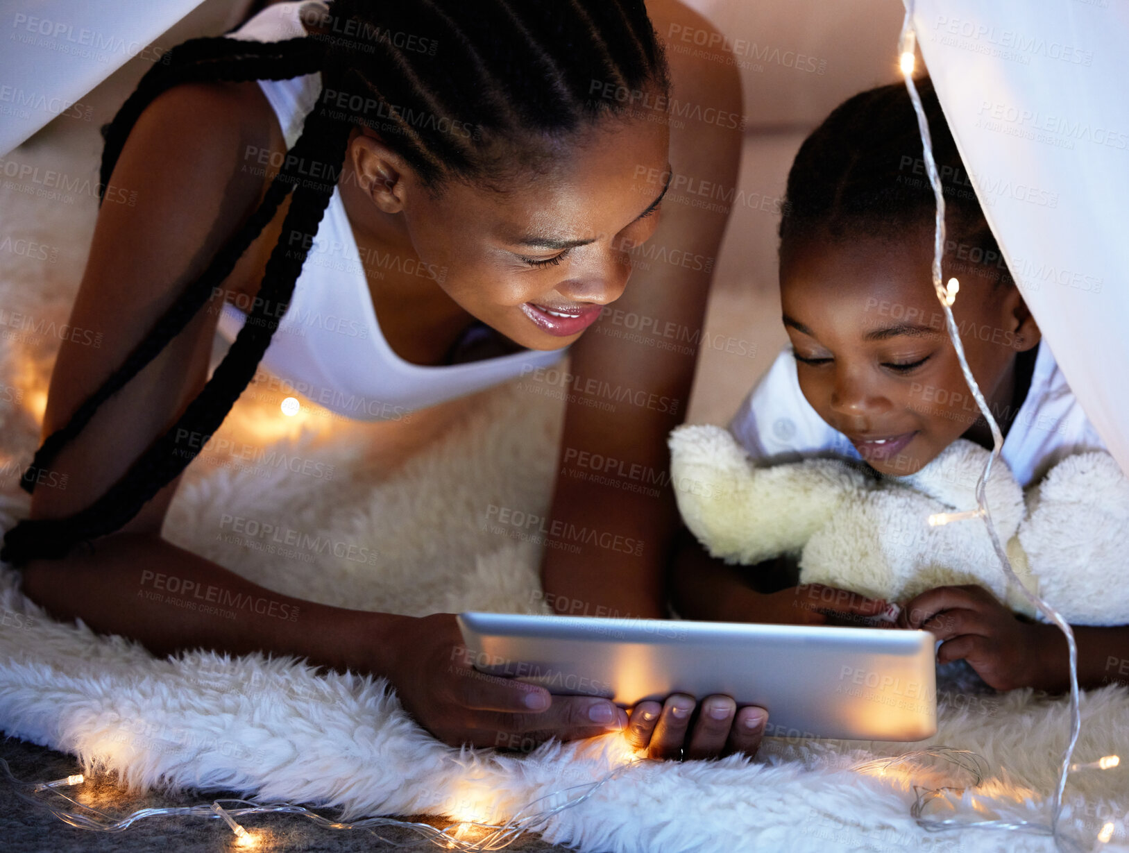 Buy stock photo Tablet, relax and mom with child in tent watching movie, video or show online in bedroom at home. Smile, love and African woman with girl kid in blanket fort streaming film on digital technology.