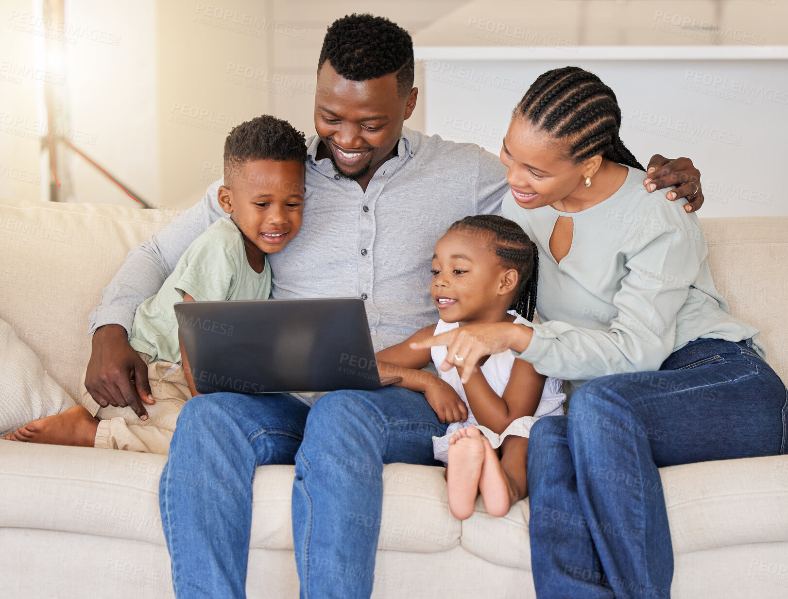 Buy stock photo Shot of a young african family watching movies together on the couch