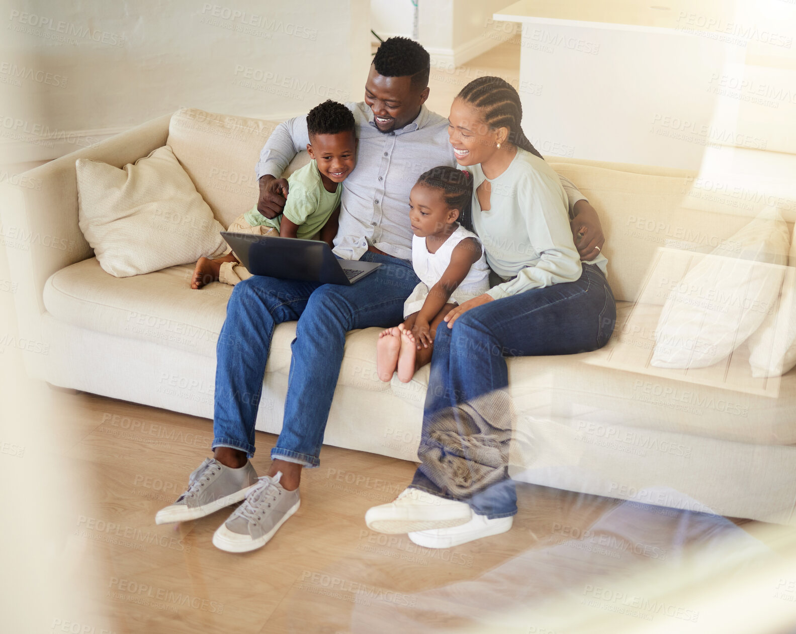 Buy stock photo Shot of a young african family watching movies on a laptop together