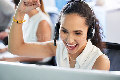 Buy stock photo Shot of an attractive young call centre agent sitting in the office and celebrating a success while using her computer