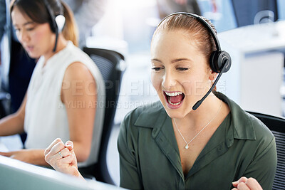 Buy stock photo Shot of an attractive young call centre agent sitting in the office and celebrating a success while using her computer