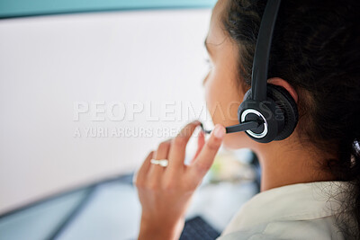 Buy stock photo Shot of an unrecognisable call centre agent sitting alone in the office and using her computer