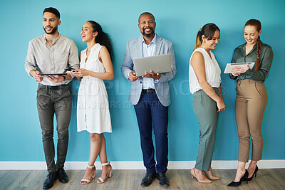 Buy stock photo Full length shot of a diverse group of businesspeople standing together in the office and using technology