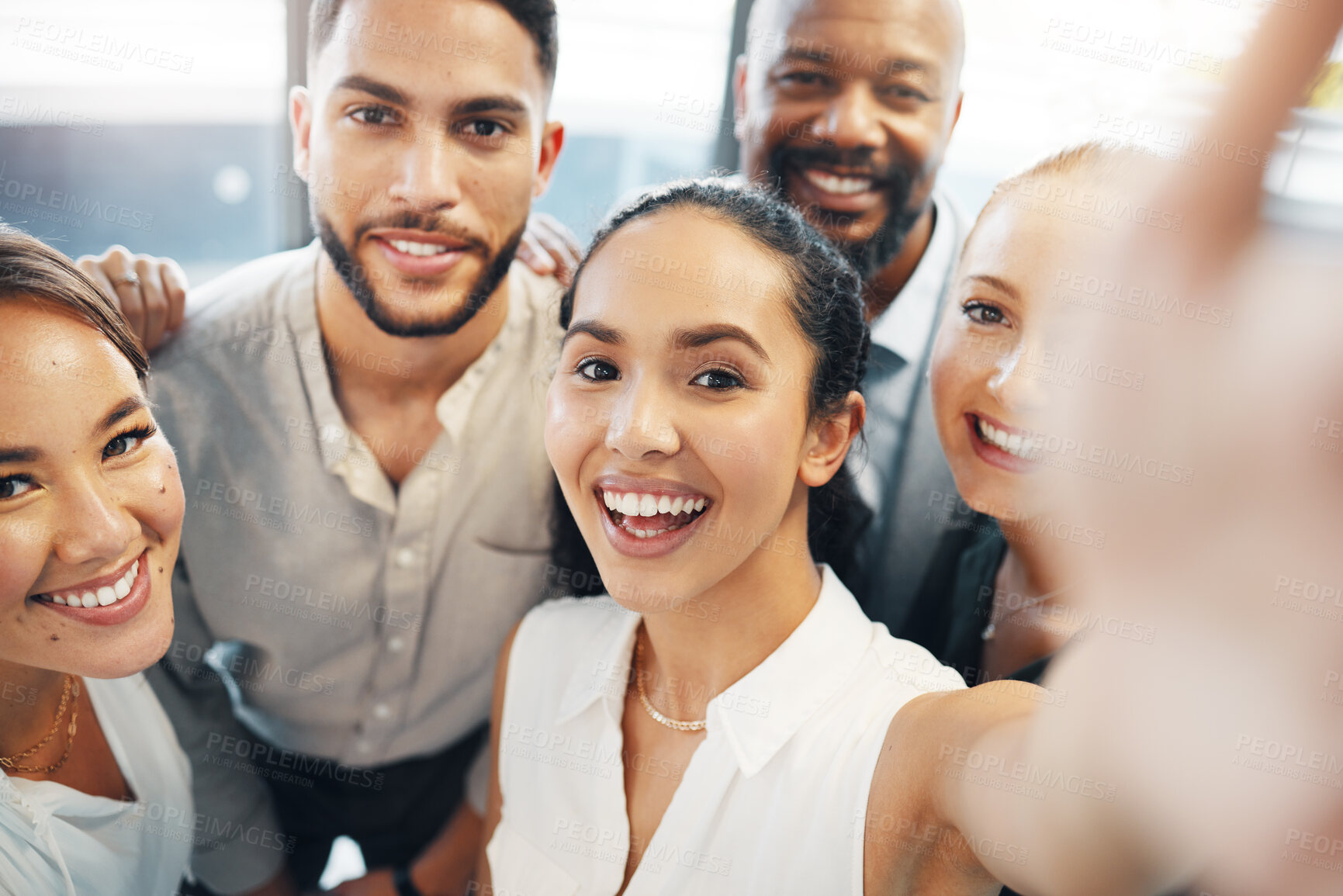 Buy stock photo Shot of a diverse group of businesspeople standing together in the office and taking selfies
