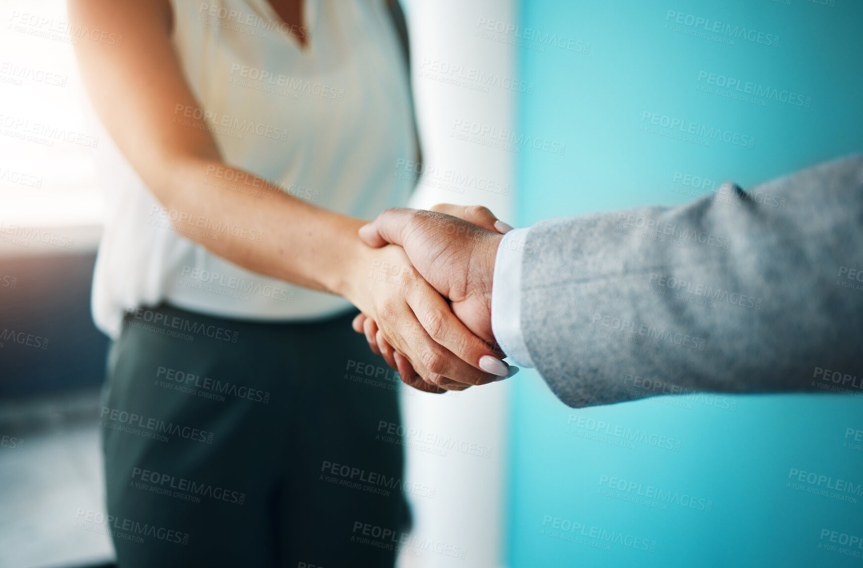 Buy stock photo Cropped shot of two unrecognisable businesspeople standing together in the office and shaking hands