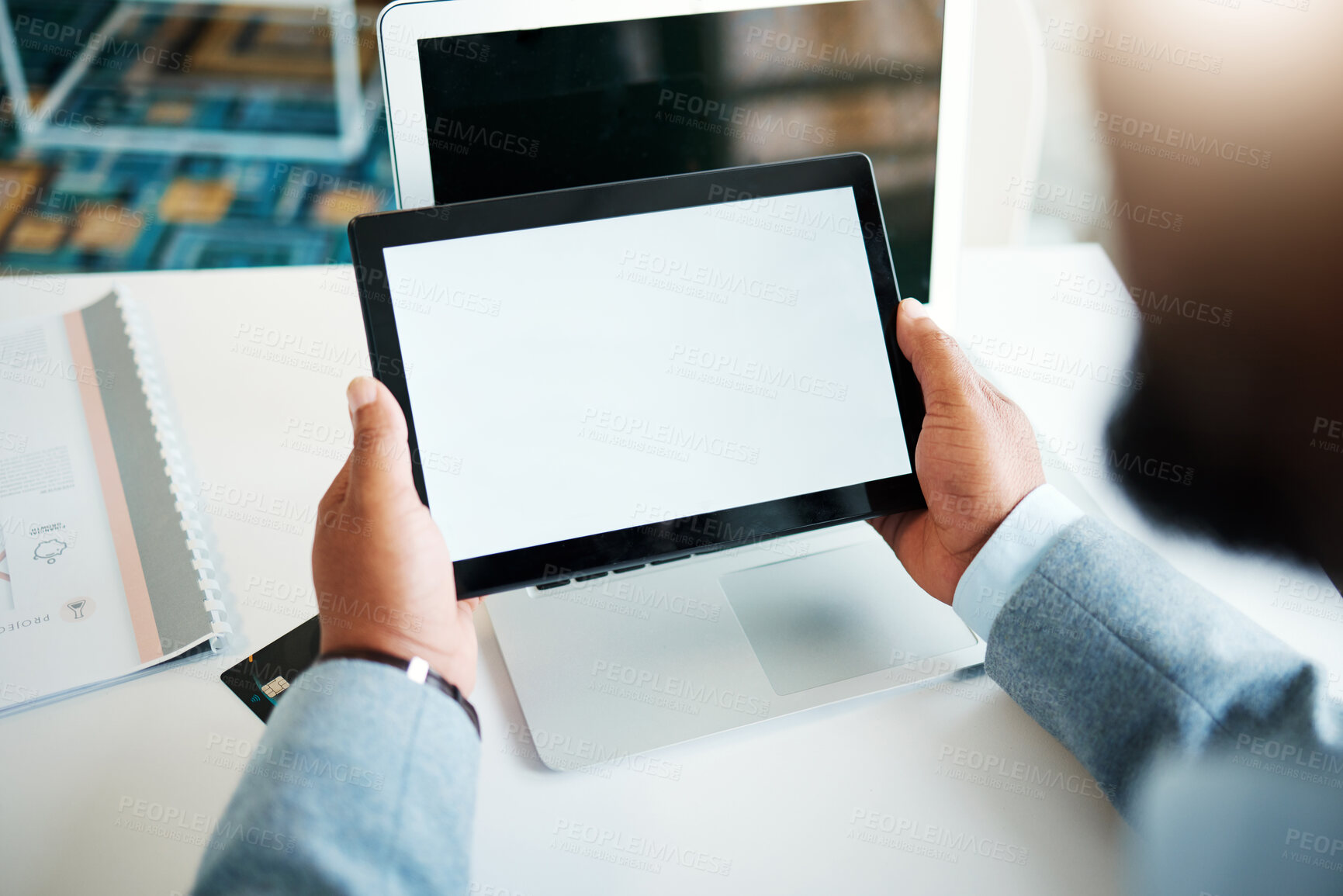 Buy stock photo Cropped shot of an unrecognisable businessman sitting alone in the office and using a digital tablet