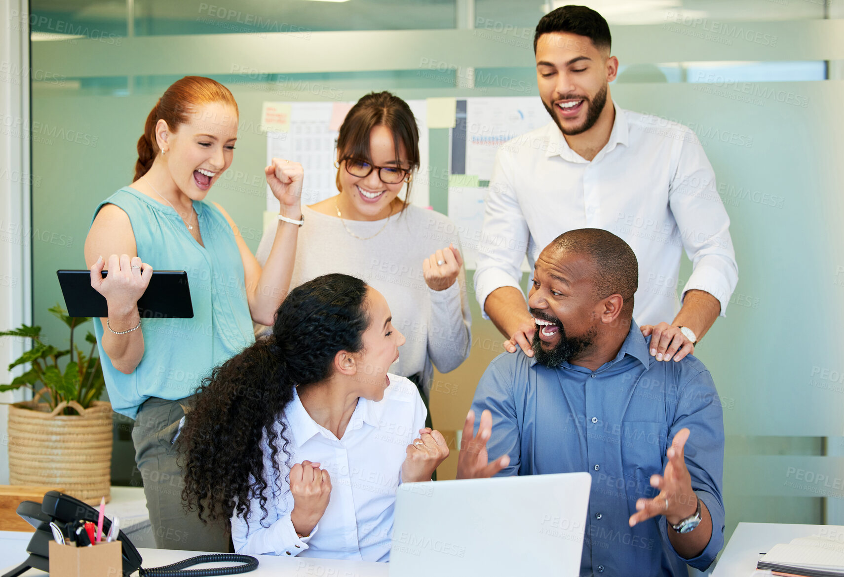 Buy stock photo Shot of a diverse group of businesspeople celebrating a success while using a laptop in the office