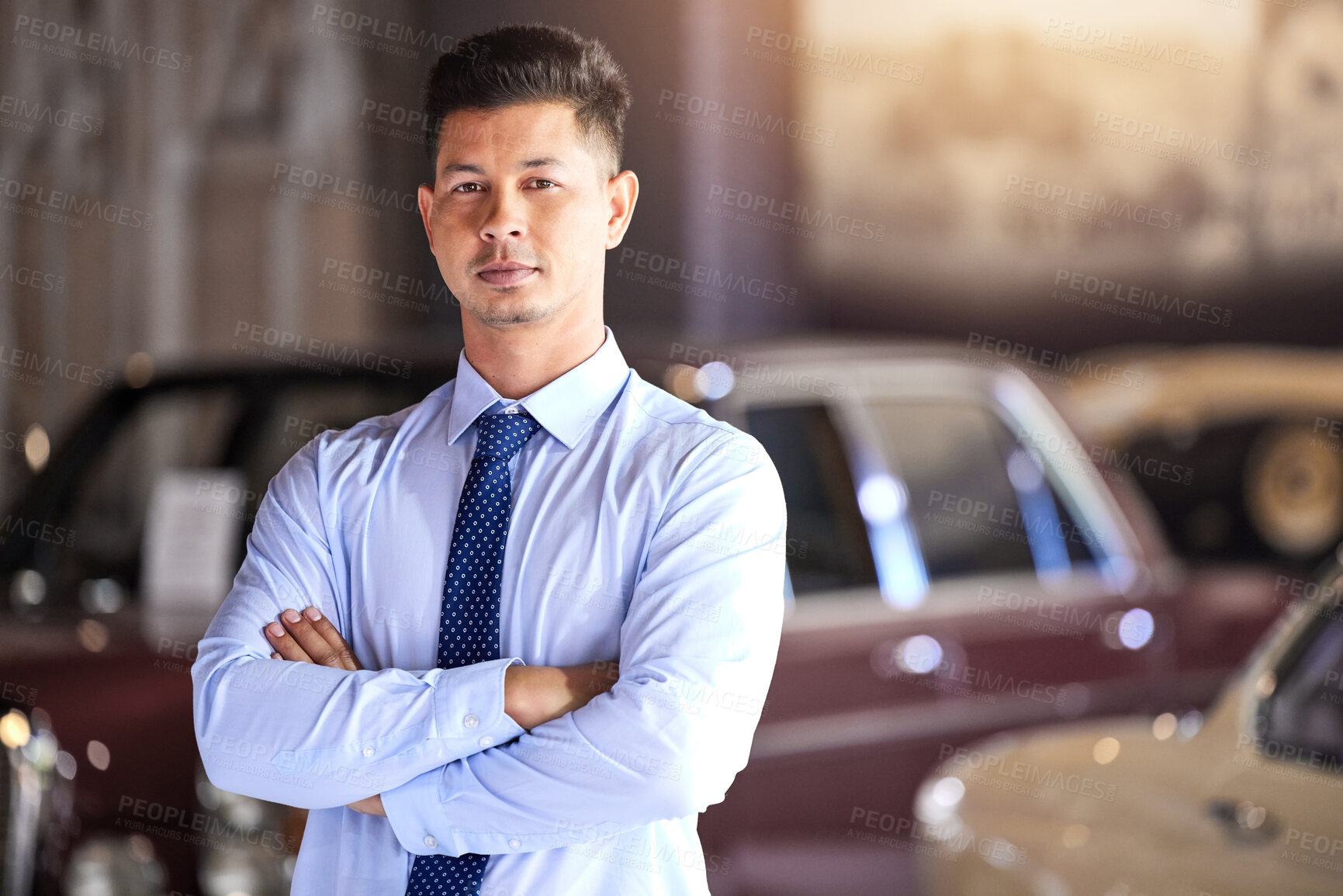 Buy stock photo Man, portrait and arms crossed at car dealership with sales, service and classic vehicle in showroom. Salesman, person or confident for discount, deal or vintage transportation for driving at store