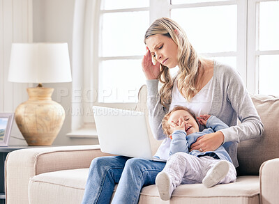 Buy stock photo Shot of a woman looking stressed while working on her laptop and sitting with her crying baby