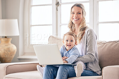 Buy stock photo Shot of a woman working on her laptop while keeping her baby on her lap