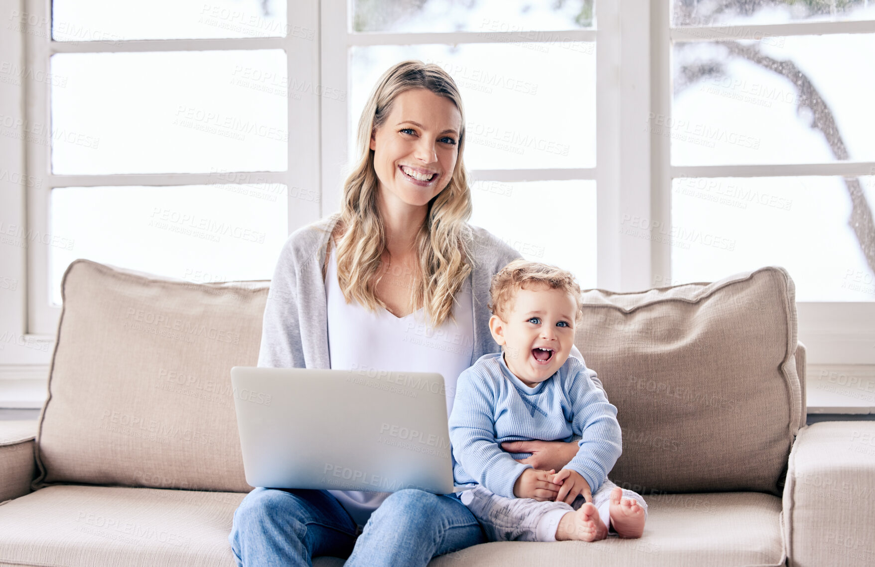Buy stock photo Shot of a woman working on her laptop while sitting with her baby