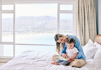 Buy stock photo Shot of a woman reading to her adorable daughter at home