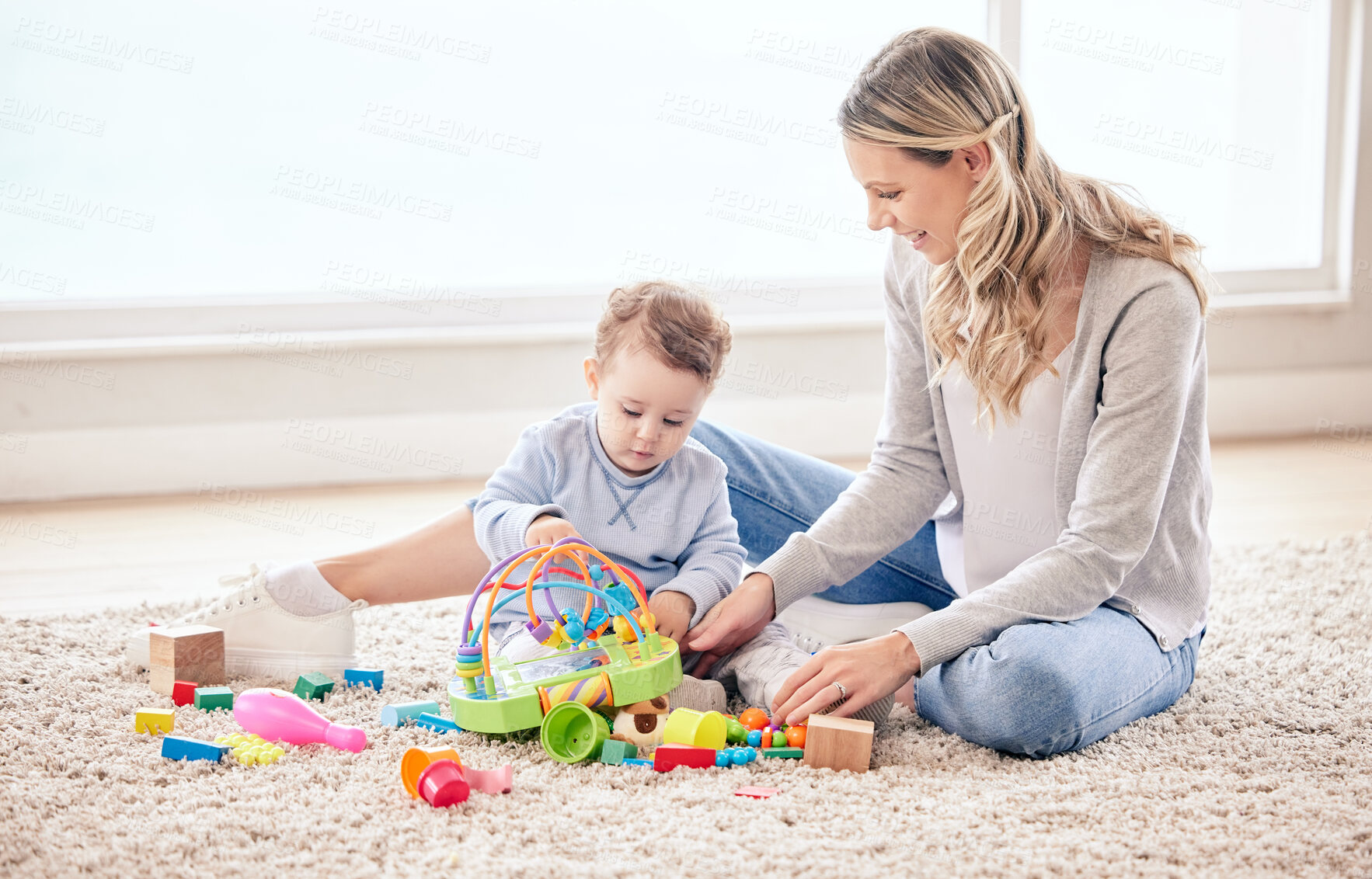 Buy stock photo Woman, toys and baby in home on bed for bonding, help and development as child with games. Mother, happy and girl in house bedroom as family for love, growth and support with care or smile on carpet