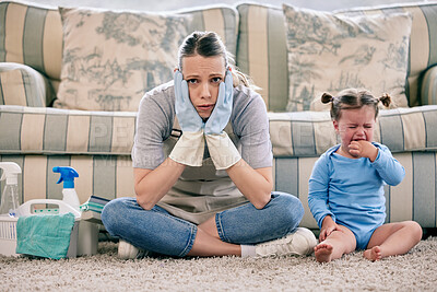 Buy stock photo Shot of a woman looking stressed while busy with chores and sitting with a crying baby at home