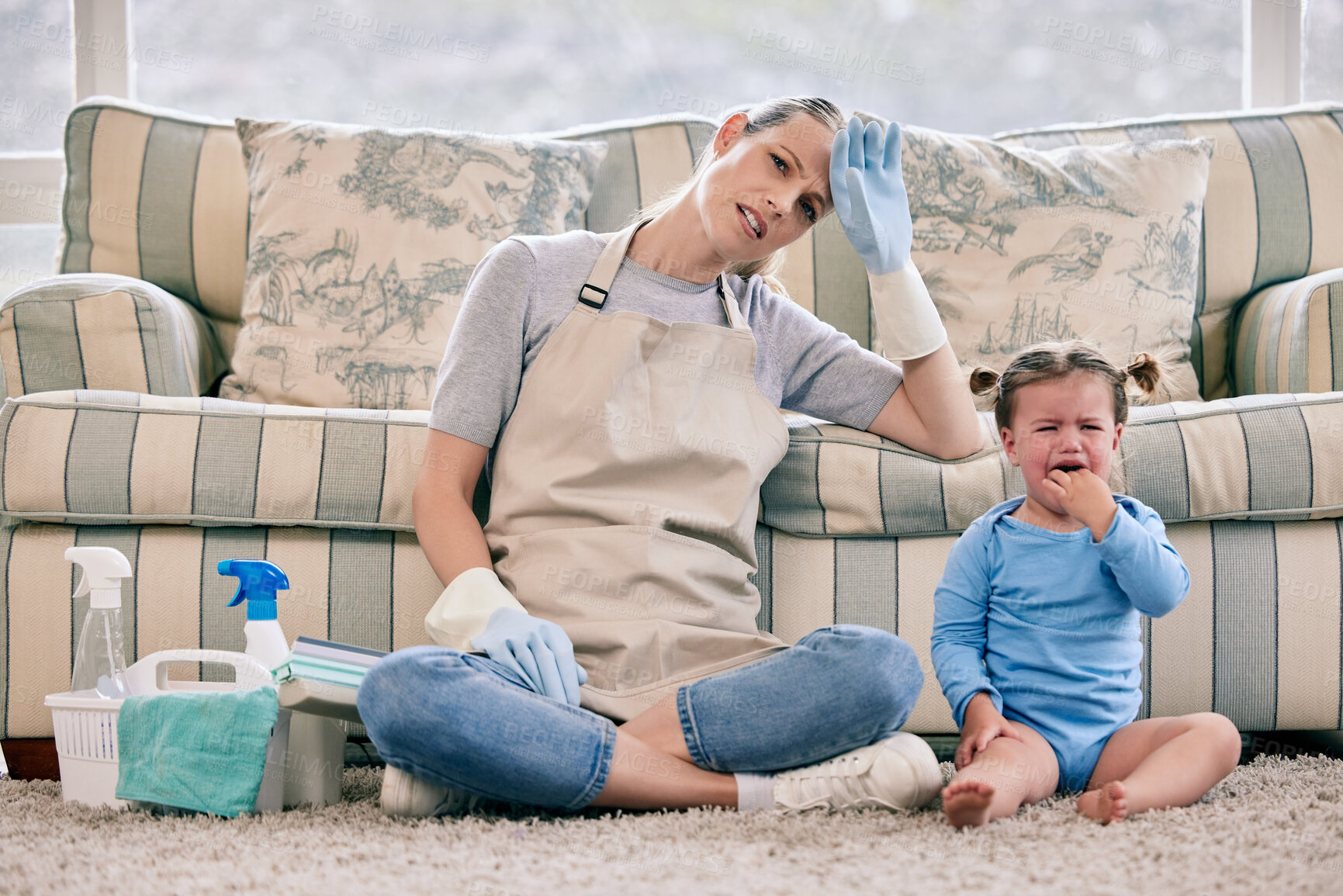 Buy stock photo Woman, tired and spring cleaning in house with baby, spray and gloves for crying and overwhelmed. Mom, burnout and housekeeping in lounge with toddler, bottle and sofa for fatigue, tantrum or stress