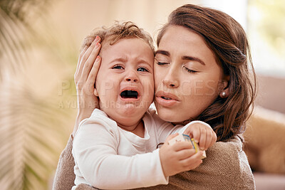 Buy stock photo Shot of a woman comforting her baby at home