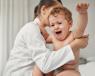Buy stock photo Shot of a little baby crying while being examined by a doctor