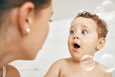 Buy stock photo Mom, baby and bubbles in bathroom for bath, cleaning and hygiene with night time routine for growth or development. Toddler, home and washing in bathtub for skin care, happiness and wellness.