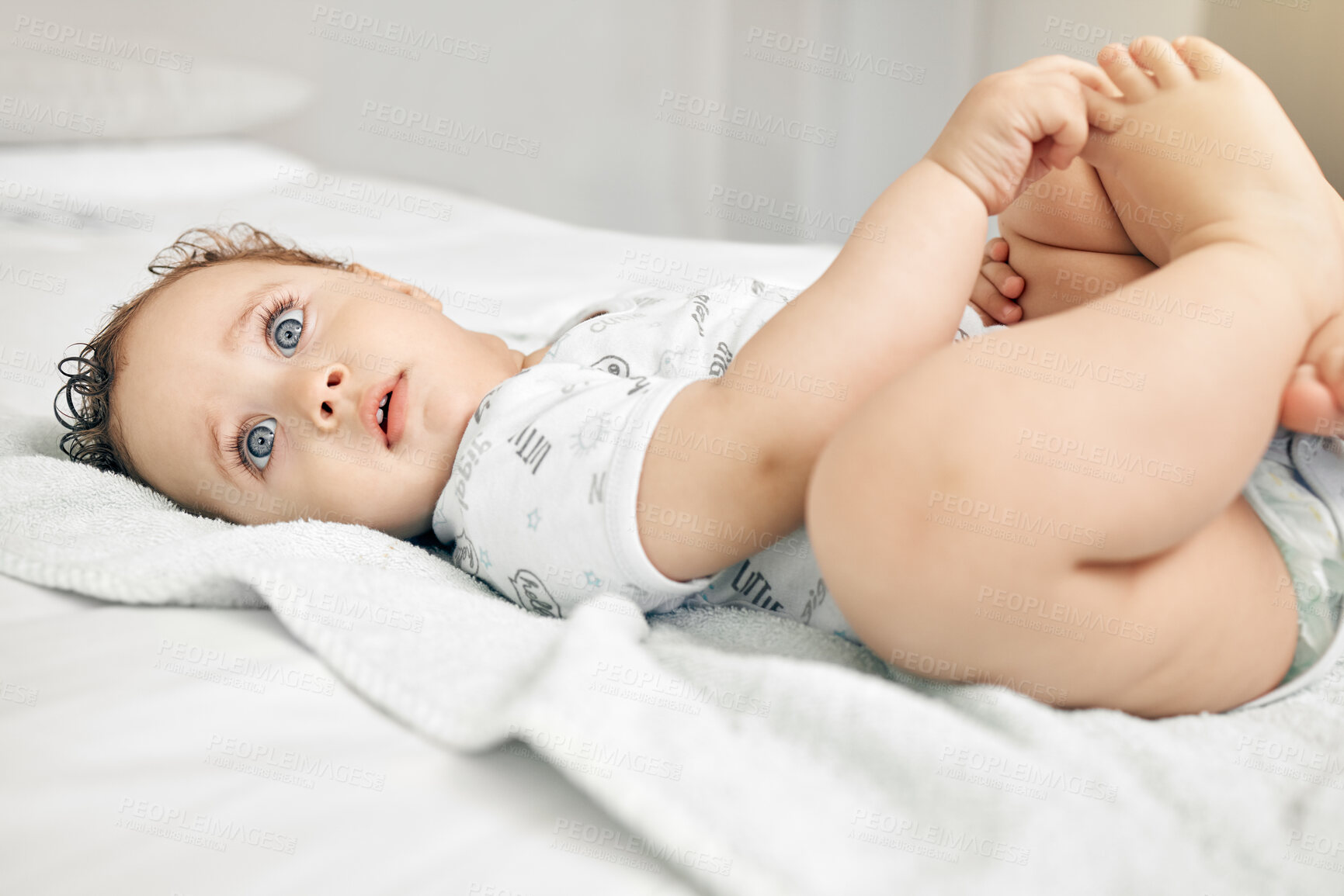 Buy stock photo Home, baby and lying on bed to relax, playful and self entertainment with curiosity for development. Bedroom, boy toddler and feet balance for rest, sensory stimulation and independence in house