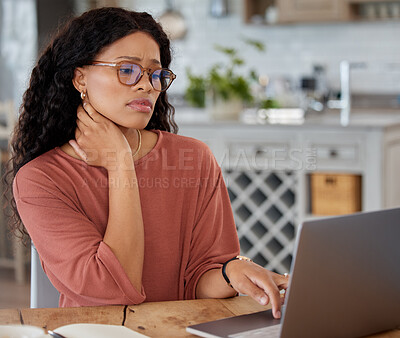 Buy stock photo Shot of a young woman looking worried while using a laptop at home