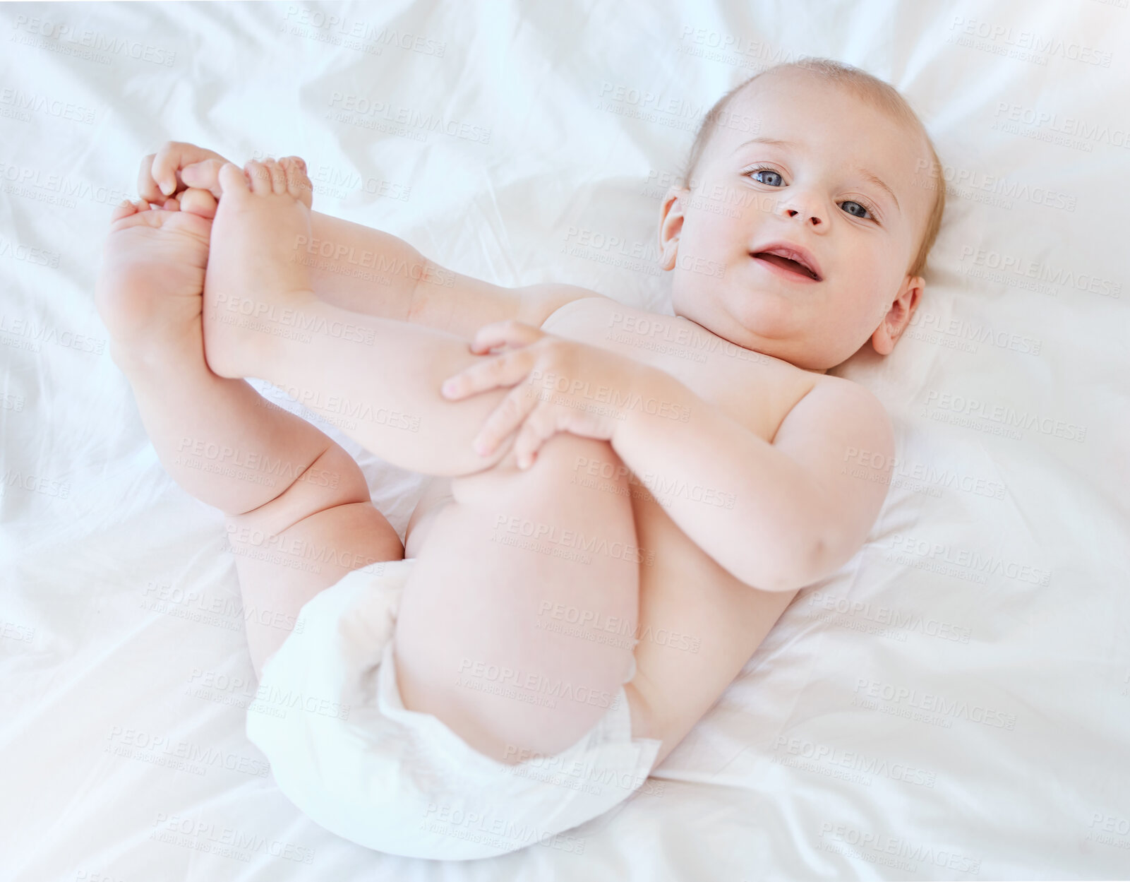 Buy stock photo Baby, legs and portrait on bed for development, relax and game or learning in home. Child, wake up and smile in nursery for motor skills and face in morning for play, wellness and healthy for growth