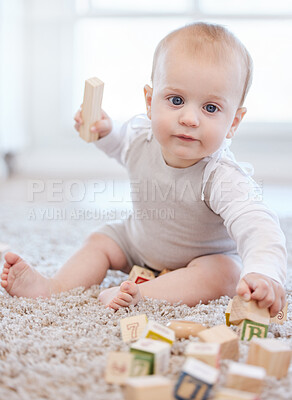 Buy stock photo Portrait, baby and playing with blocks on floor for learning, development and motor skills in home. Young kid, wood toys and creativity on carpet for growth with sensory education and alphabet puzzle