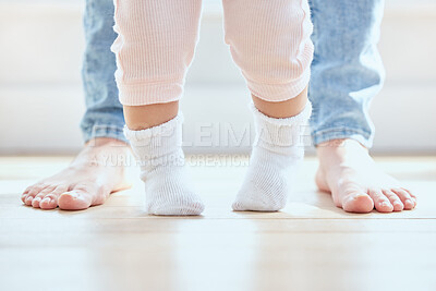 Buy stock photo Feet, baby and person walking in home for growth, development and support for childhood. First steps, legs and kid with mother in lounge for learning, teaching and together for exercise and balance 