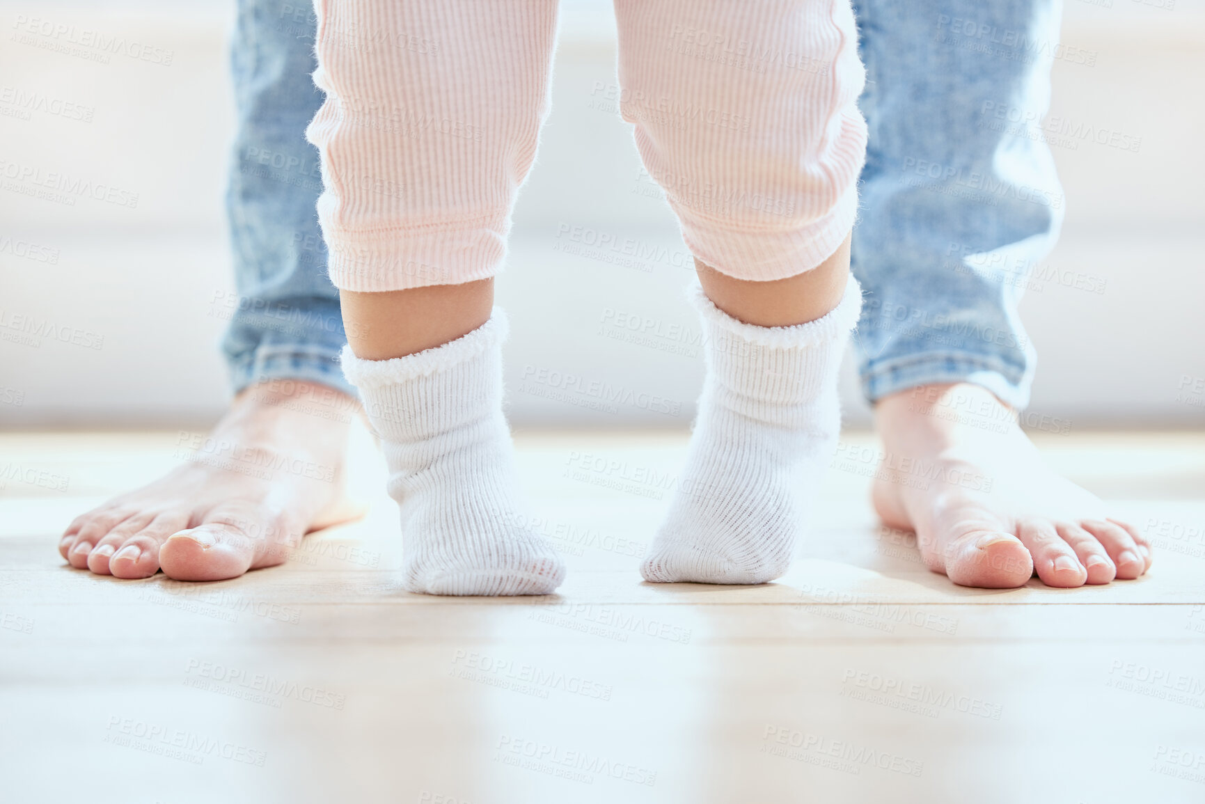 Buy stock photo Feet, baby and person walking in home for growth, development and support for childhood. First steps, legs and kid with mother in lounge for learning, teaching and together for exercise and balance 