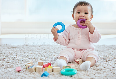 Buy stock photo Baby, portrait and playing with toy on floor in home for sensory development, teething progress and biting. Infant, person and silicone ring in mouth for tooth growth, gums satisfaction and chewing