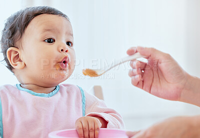 Buy stock photo Mother, feeding baby girl and spoon in home, kitchen or living room for nutrition, growth or health. Woman, hand and food for infant child for help, eating or balance in diet for development in house