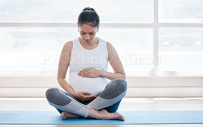 Buy stock photo Shot of a pregnant woman doing yoga at home