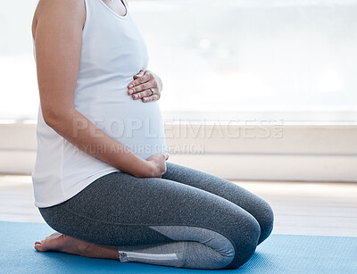 Buy stock photo Shot of a pregnant woman doing yoga at home