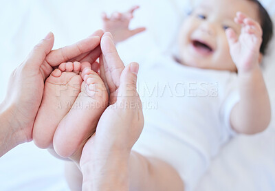 Buy stock photo Shot of a mother bonding her baby girls feet at home