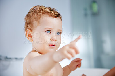 Buy stock photo Baby, bathroom and pointing in bathtub for hygiene with playing, fun and support for childcare. Toddler, kid and washing body at home for child development or growth to relax, enjoy and bathing