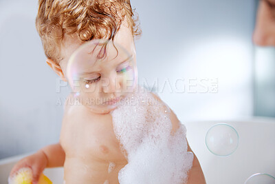 Buy stock photo Baby, bathroom and bubbles in bathtub for hygiene with playing, fun and support for childcare. Toddler, kid and washing body at home for child development or growth to relax, enjoy and soap with foam