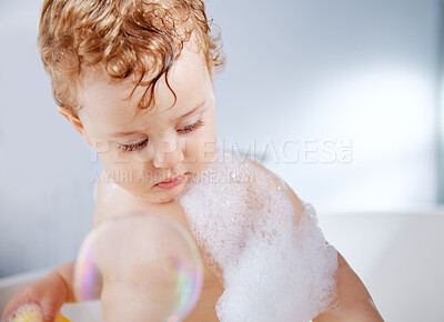 Buy stock photo Baby, bathroom and bubbles in bathtub for hygiene with playing, fun and support for childcare. Toddler, kid and washing body at home for child development or growth to relax, enjoy and soap with foam