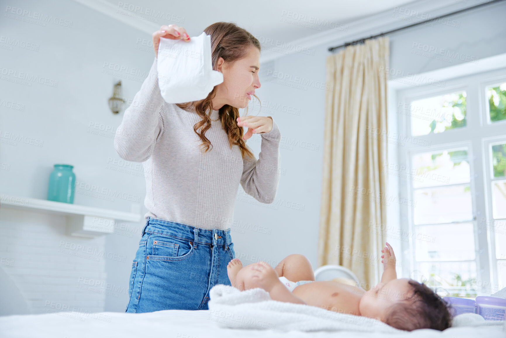 Buy stock photo Shot of a mother changing her baby's dirty diaper
