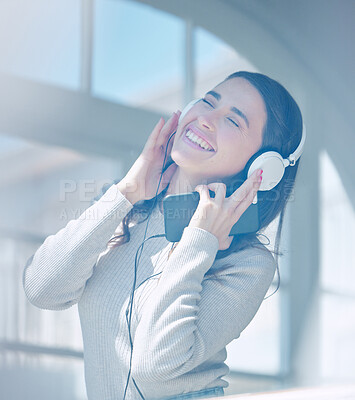 Buy stock photo Cropped shot of an attractive young woman listening to music while relaxing in the living room at home
