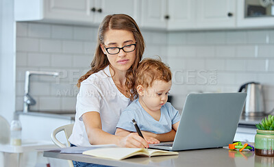 Buy stock photo Cropped shot of an attractive young businesswoman working at home while looking after her baby boy