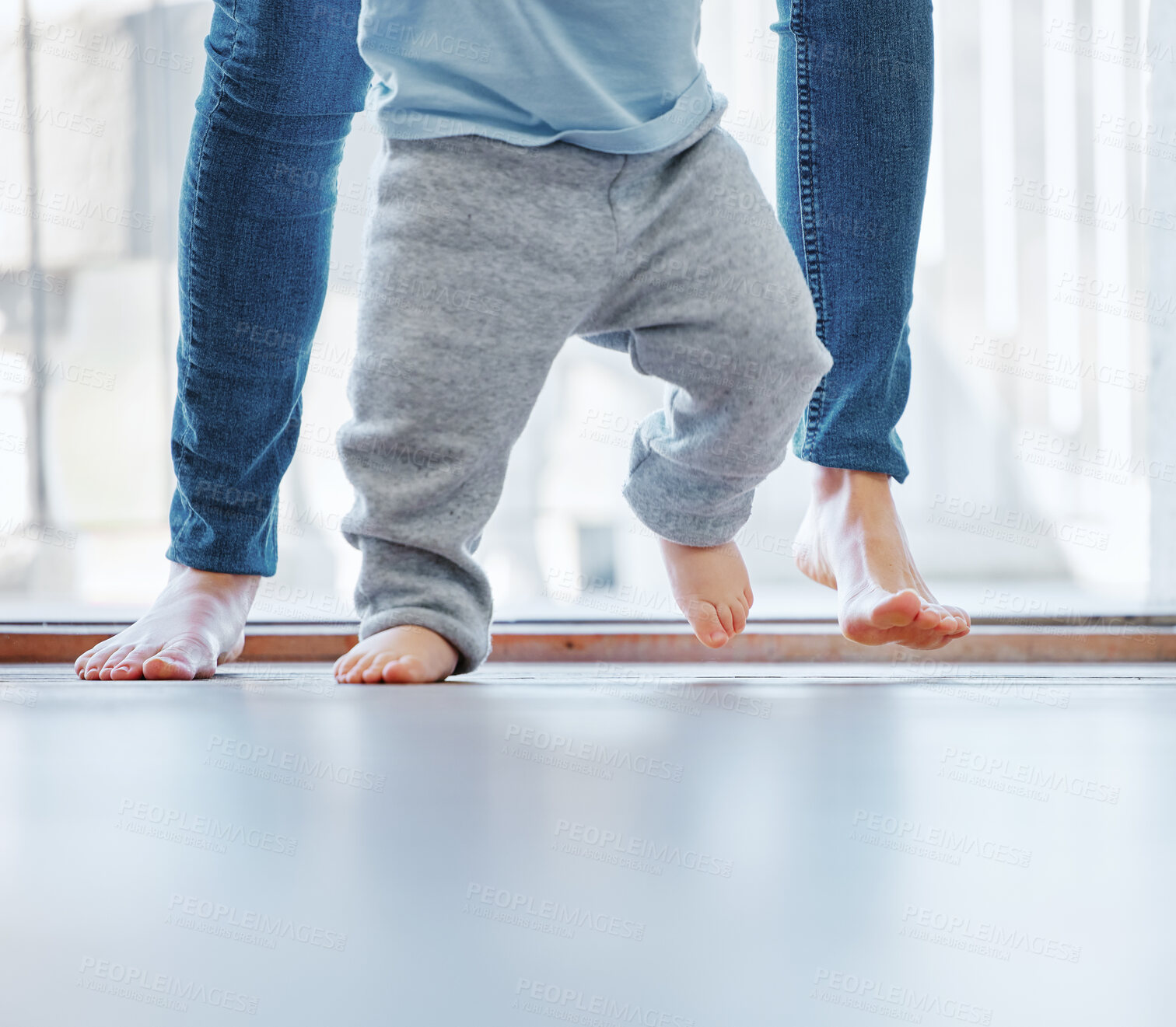 Buy stock photo Cropped shot of an unrecognizable little boy learning to walk with the help of his mother at home