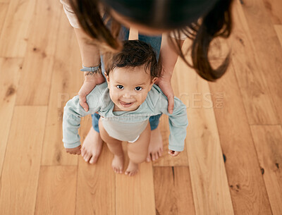 Buy stock photo Shot of an adorable baby walking with the support of her mother