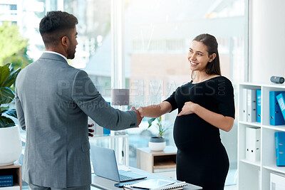 Buy stock photo Shot of a pregnant businesswoman shaking hands with a businessman in an office