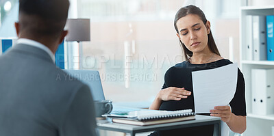 Buy stock photo Shot of a young businesswoman going through a resume from an applicant during a job interview in an office